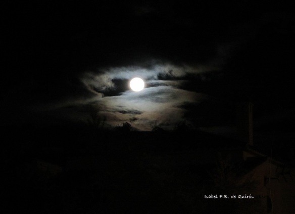 Luna llena asomando entre las nubes que cubren el cielo/ Full Moon peeking through the clouds